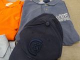 a pile of clothing and a hat sitting on a bed