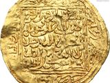 a close up of a gold coin with arabic writing on it