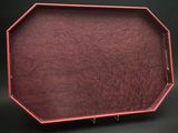 une image représentant un plateau rouge posé sur une table noire