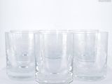 four glasses are lined up in a row on a white surface
