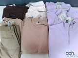 de nombreux t-shirts et pantalons de différentes couleurs posés sur une table