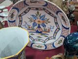 de nombreux vases et assiettes de toutes sortes sur la table