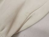 the bottom of a pair of white pants with a white shirt underneath it