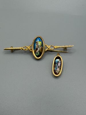 une paire de barrettes dorées ornées d'une image représentant un homme et une femme
