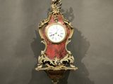 une horloge rouge et dorée accrochée au mur
