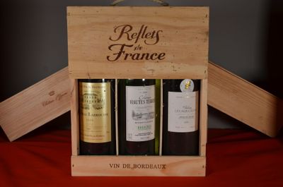 three bottles of wine in a wooden box on a table