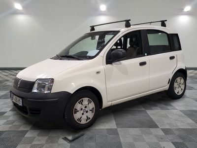 une petite camionnette blanche garée sur un sol à damier
