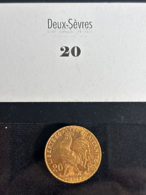 a gold coin in a black box with a white label