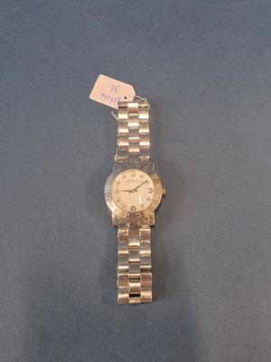 une image représentant une montre-bracelet posée sur un fond bleu, avec une étiquette de prix