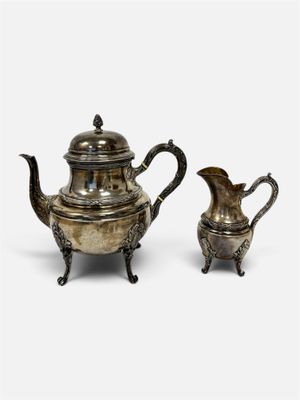 deux théières en métal argenté et une cafetière, posées sur des socles