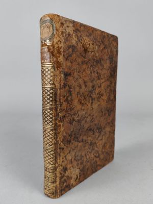 an old book sitting on top of a white surface