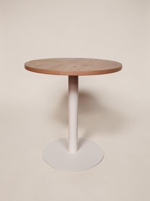 une table ronde avec un piètement blanc et un plateau en bois