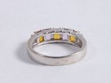 a close up of a ring on a white surface with a pink and yellow diamond