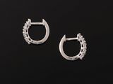 a pair of silver hoop earrings on a black background