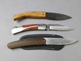 several knives are lined up on a table with a leather sheath