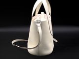 white leather handbag on a black surface with a black background