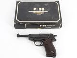 a gun and a box on a white surface