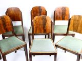 six chaises en bois aux assises rembourrées vertes sont disposées en cercle