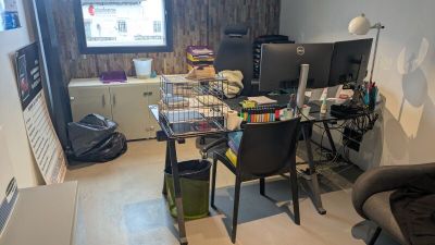 une pièce équipée d'un bureau, d'une chaise et d'un écran d'ordinateur