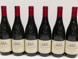 six bouteilles de vin rouge alignées sur une table