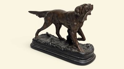 statue en bronze représentant un chien, posée sur un socle noir