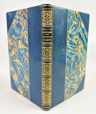 un vieux livre à la couverture bleue, rehaussée de dorures sur fond blanc