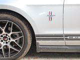 a close up of a white car with a red, white, and blue stripe on the side