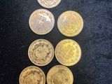 a pile of gold coins sitting on top of a black surface