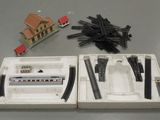 a box of train tracks and a model house on the table