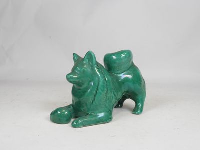 green ceramic cat figurine sitting on a white surface