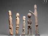 a group of four wooden figures standing next to each other