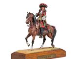 statue of a man riding a horse on a wooden base