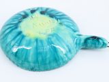 a blue and green turtle shaped object on a white surface