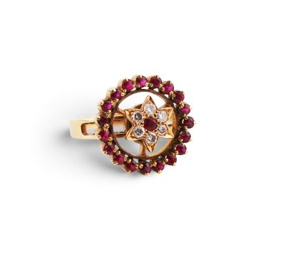 a close up of a gold ring with red and white stones
