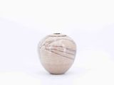 a small vase that is sitting on a white surface