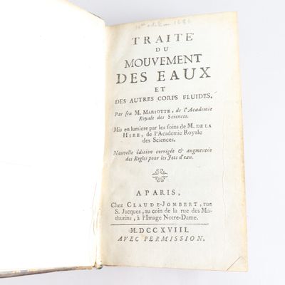 un livre ouvert sur une surface blanche, dont le titre est en français