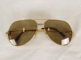 sunglasses on a white cloth with a reflection of a person ' s face