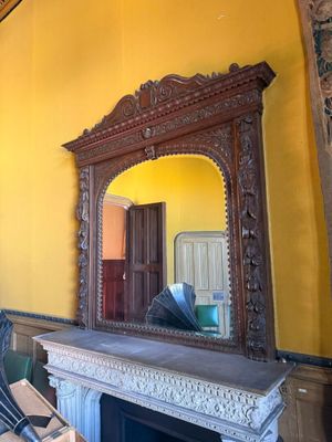 un miroir accroché au mur au-dessus de la cheminée d'une pièce