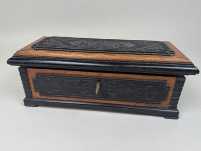 une vieille boîte en bois ornée d'un motif noir et marron