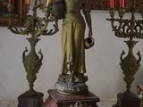 une statue représentant une femme tenant un candélabre devant lequel se trouvent des bougies