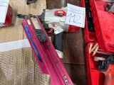 une boîte rouge contenant un pistolet à clous et une boîte rouge contenant un pistolet à clous