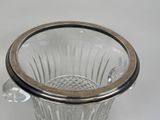 a glass vase with a silver rim on a white surface
