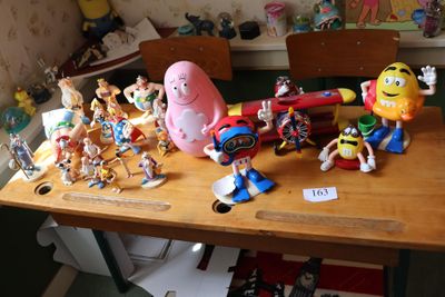 des figurines de jouets posées sur une table en bois dans une pièce encombrée
