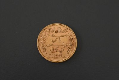 a close up of a gold coin on a black surface