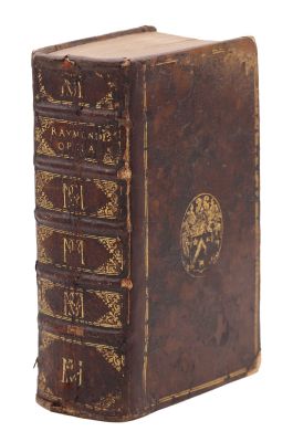 an old brown book with gold writing on it sitting on top of a white surface