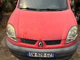 une voiture rouge garée sur la terre battue