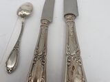 three silver spoons and two silver spoons on a white surface