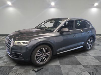 un SUV Audi gris garé dans un garage au sol carrelé
