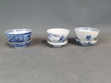 trois tasses et soucoupes bleues et blanches posées sur une table