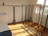 a room with a bed, luggage, and a rack in it
